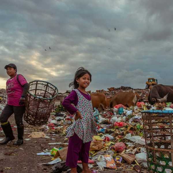 Denizens of the Suwung Landfill in Bali. Family of trash pickers with bovines in the background.