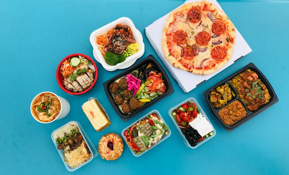 Different meals in various plastic containers on a blue background.