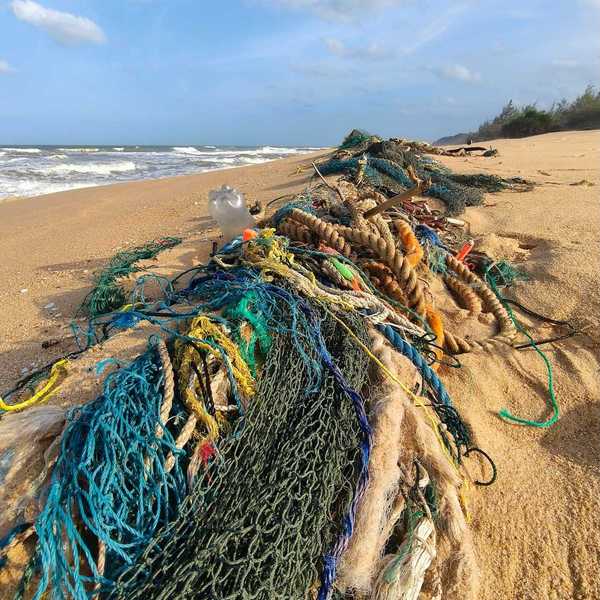 Discarded fishing gear along a beach - multicolored ropes and netting