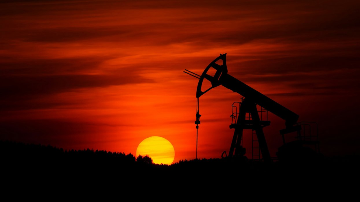 drilling rig with sunset behind it