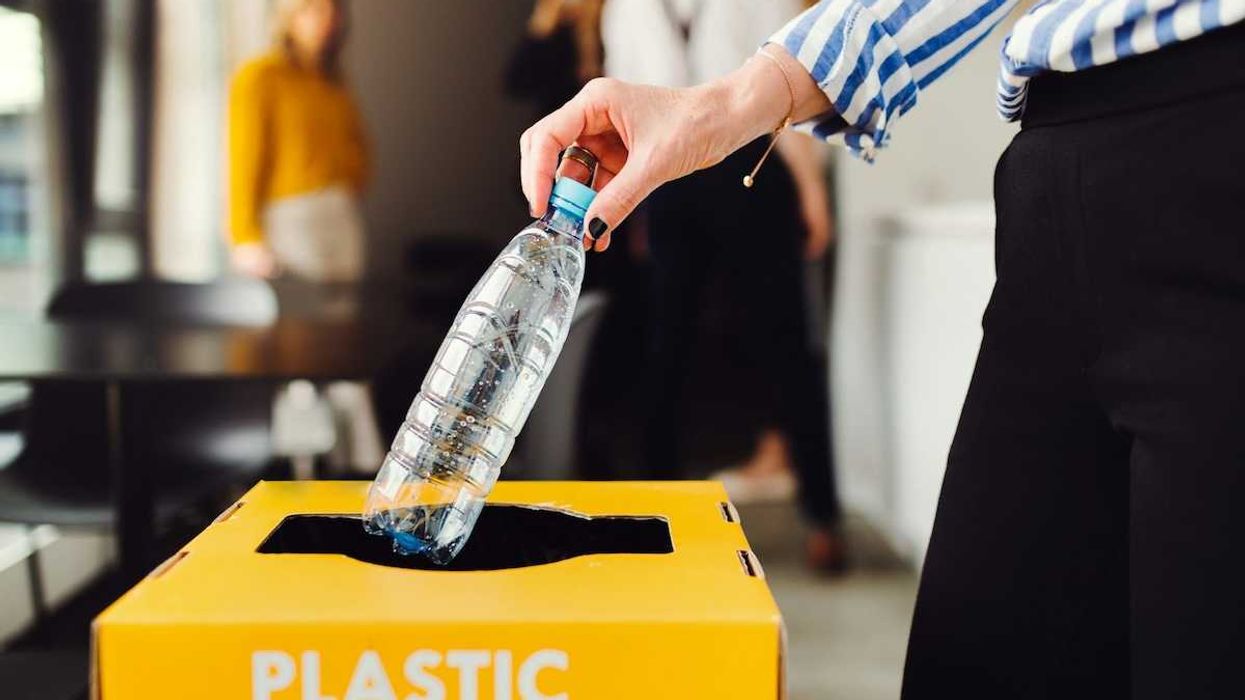 Dropping plastic bottle into recycling