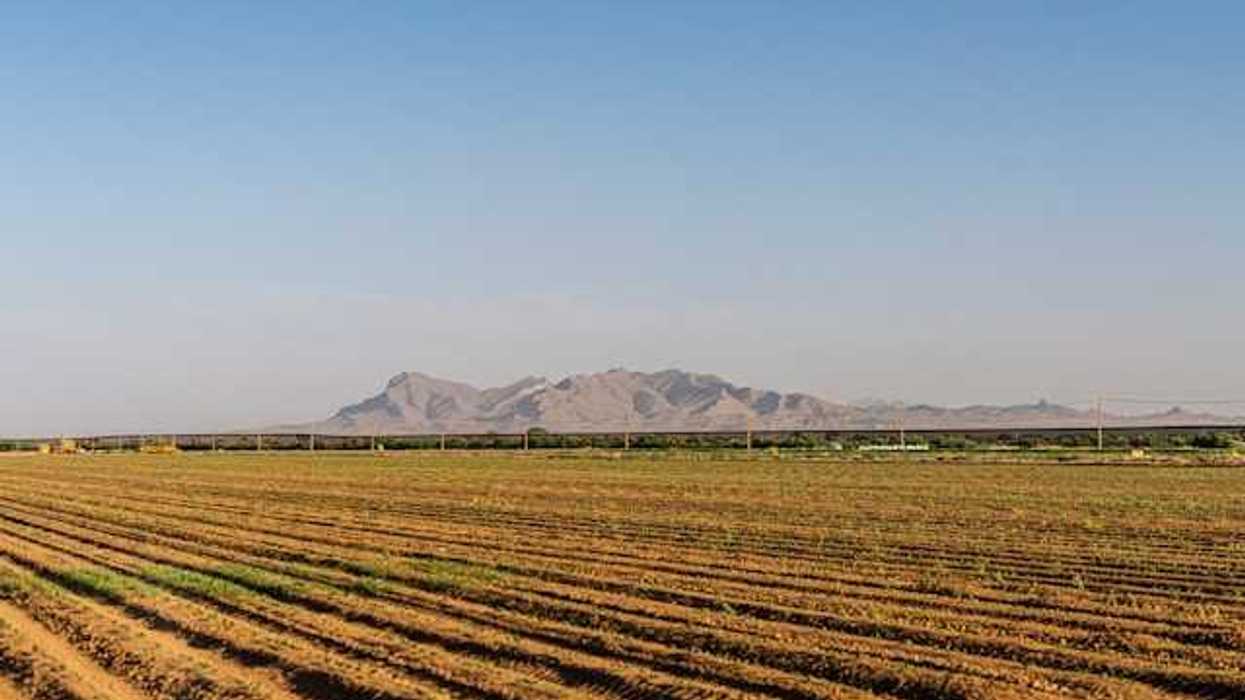 Dry farm fields with mountains in the background