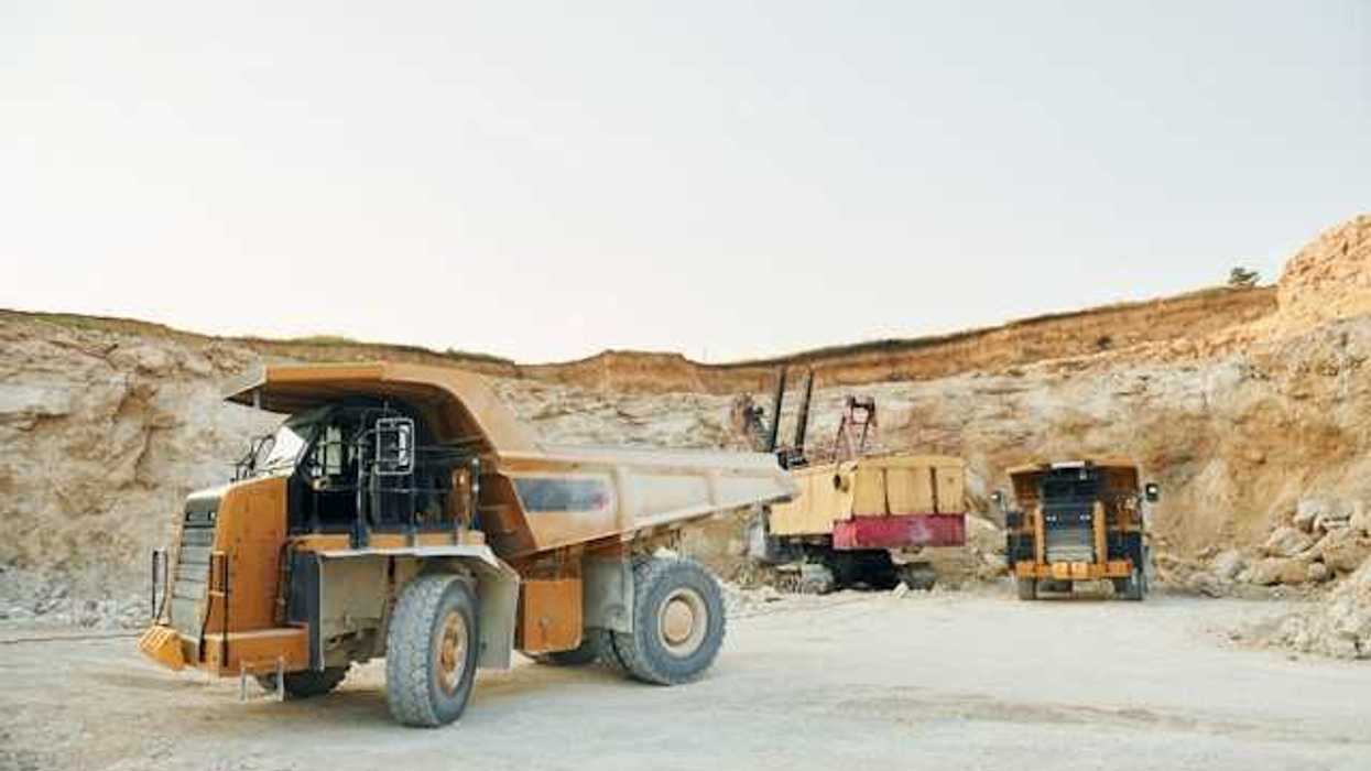 Dump trucks and mining equipment at the bottom of a mining pit