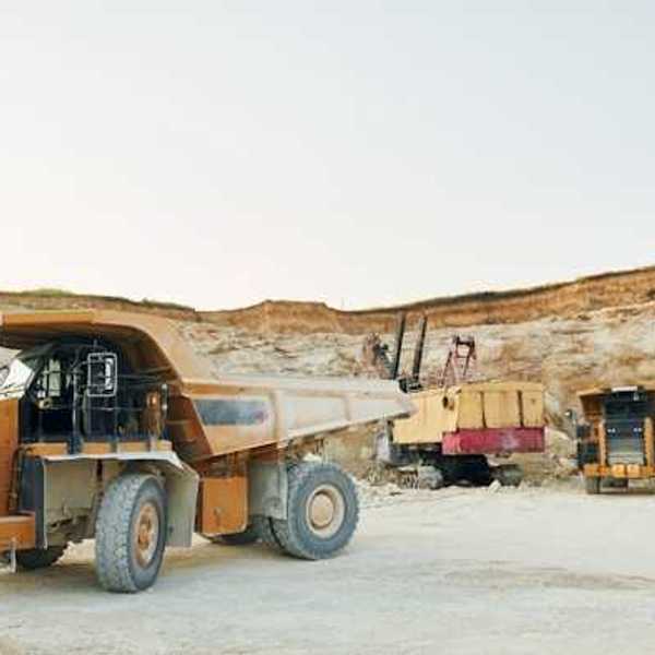 Dump trucks and mining equipment at the bottom of a mining pit