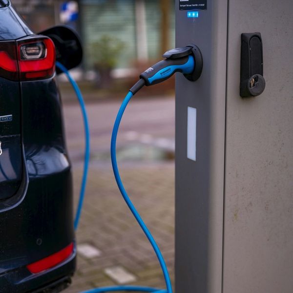 Electric vehicle plugged into charging station