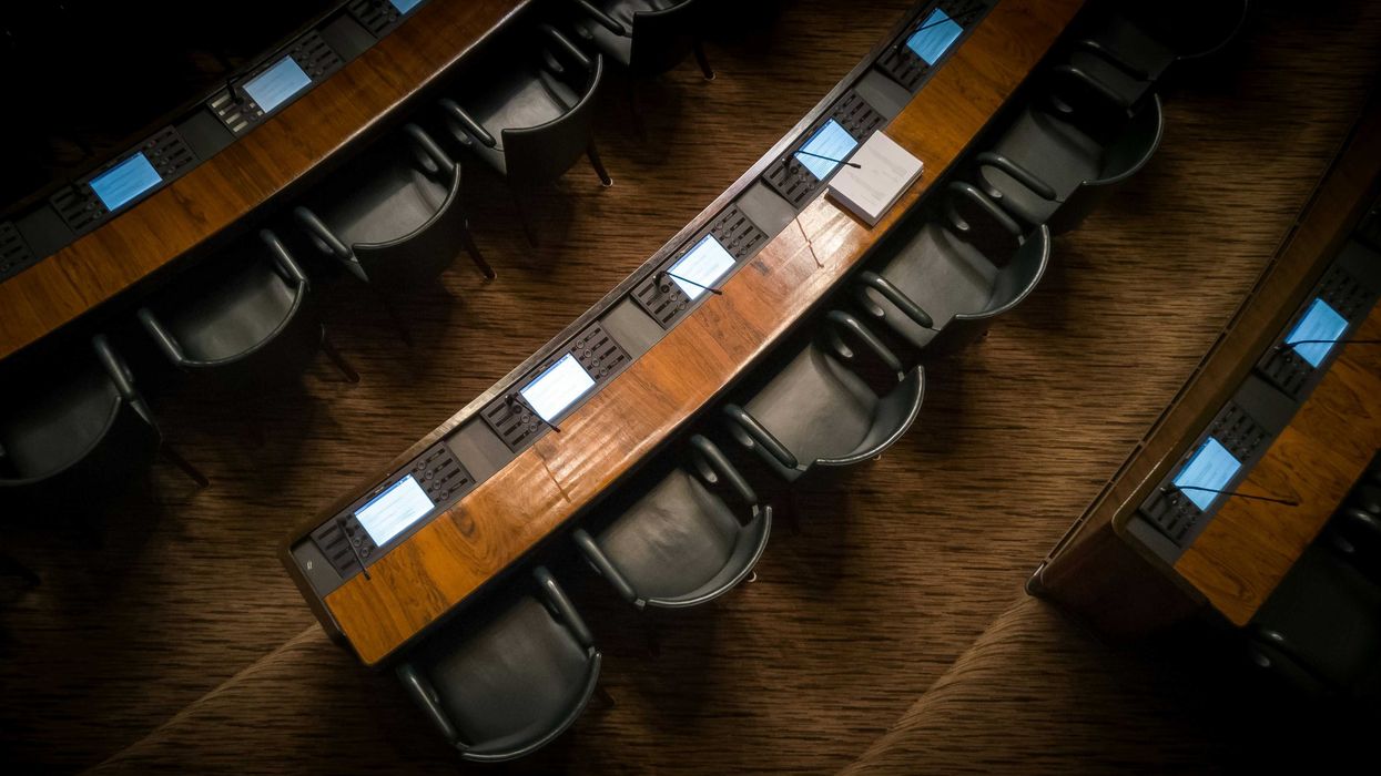 Empty chairs in rows inside a capitol building.