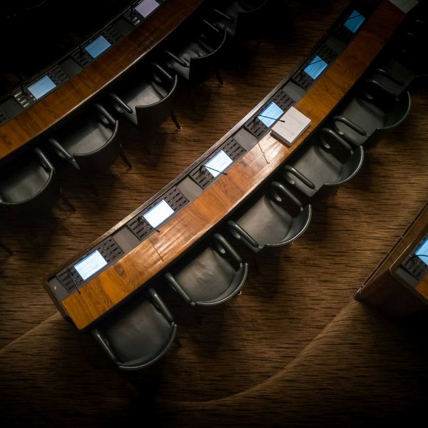 Empty chairs in rows inside a capitol building.