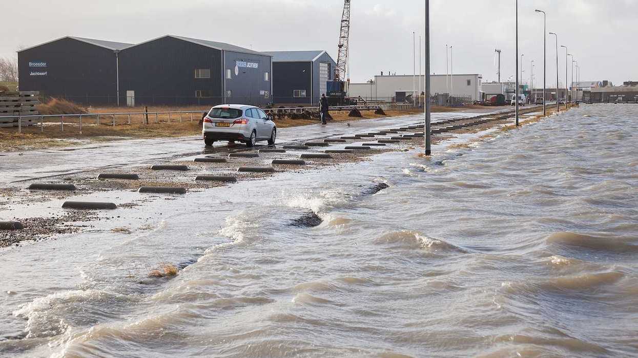 Extreme high tide and flooded roadway at the dikes of the Dutch coastal works