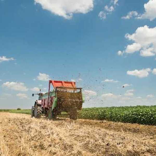 Farm manure being spread on a field