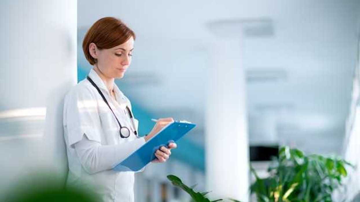 Female doctor writing on a clipboard in a hospital