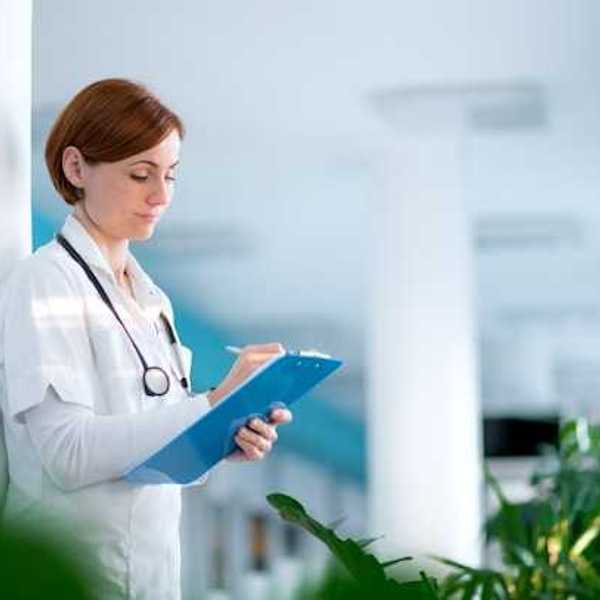 Female doctor writing on a clipboard in a hospital
