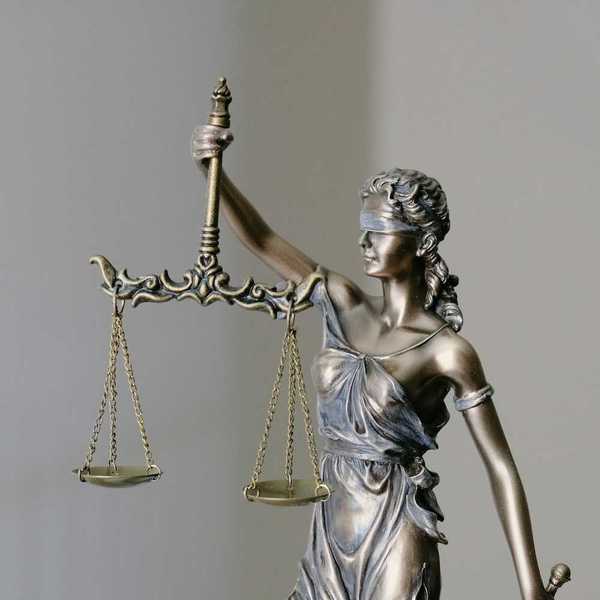 Figure of "lady justice" holding scales of justice in right hand