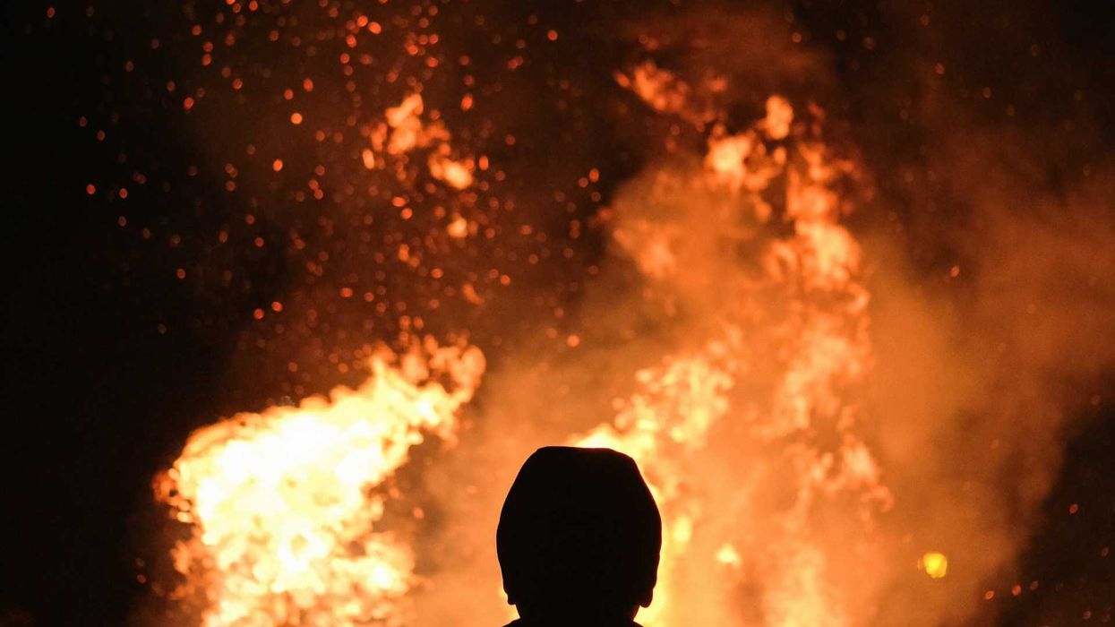 Figure silhouetted against wildfire