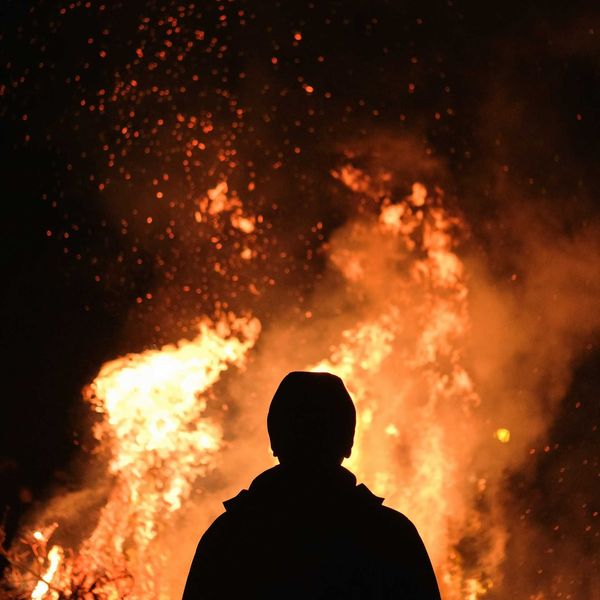 Figure silhouetted against wildfire