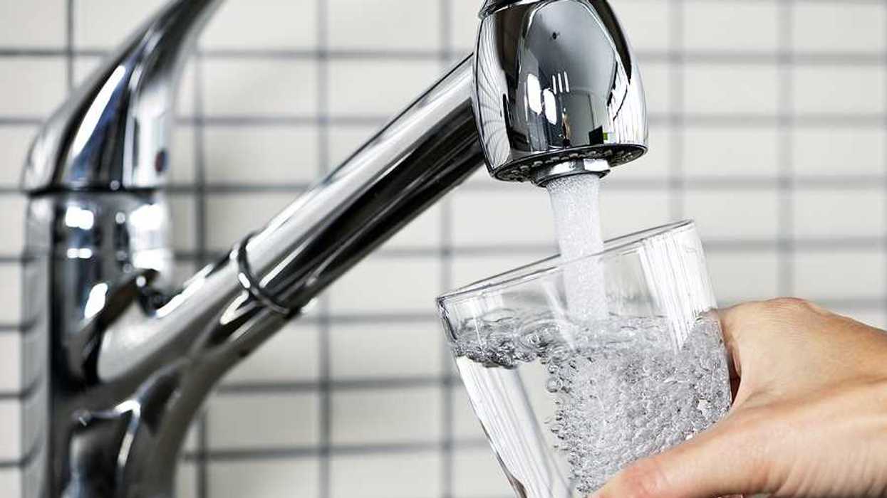 Filling glass of water from stainless steel kitchen faucet.