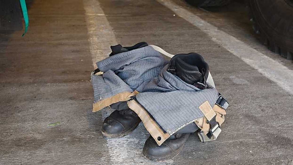 Firefighter pants and boots on a cement floor waiting for a firefighter to put them on