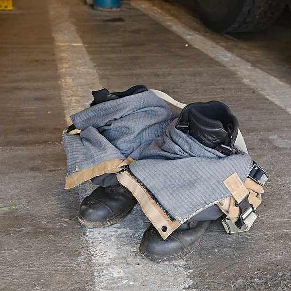 Firefighter pants and boots on a cement floor waiting for a firefighter to put them on