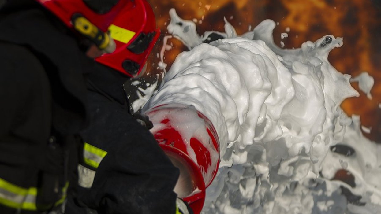 firefighter spraying foam