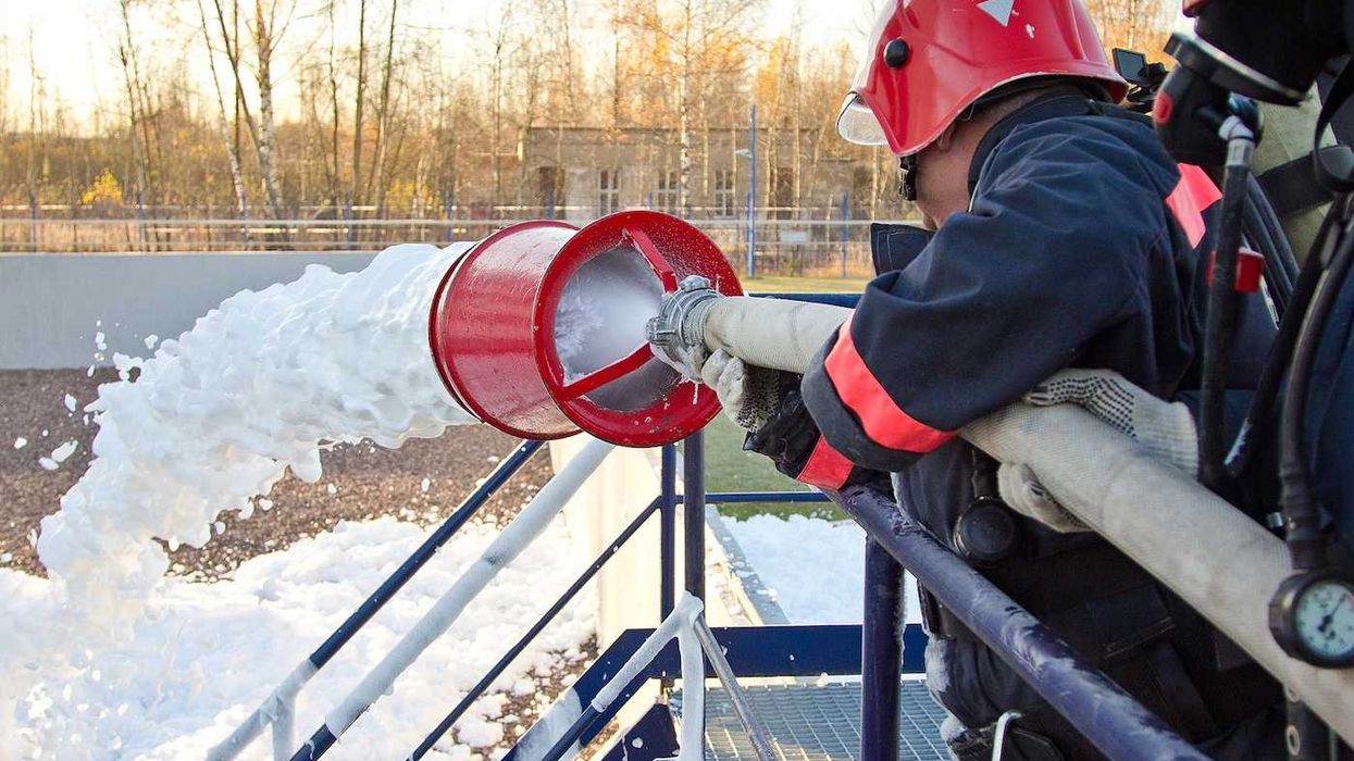 Fireman extinguishing a fire using firefighting foam