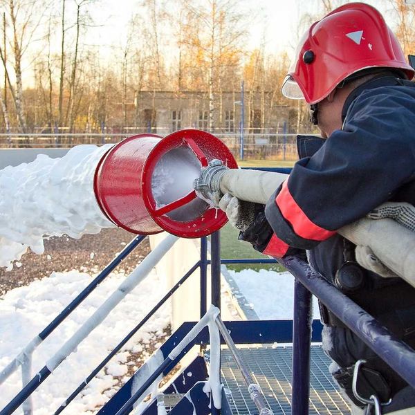 Fireman extinguishing a fire using firefighting foam