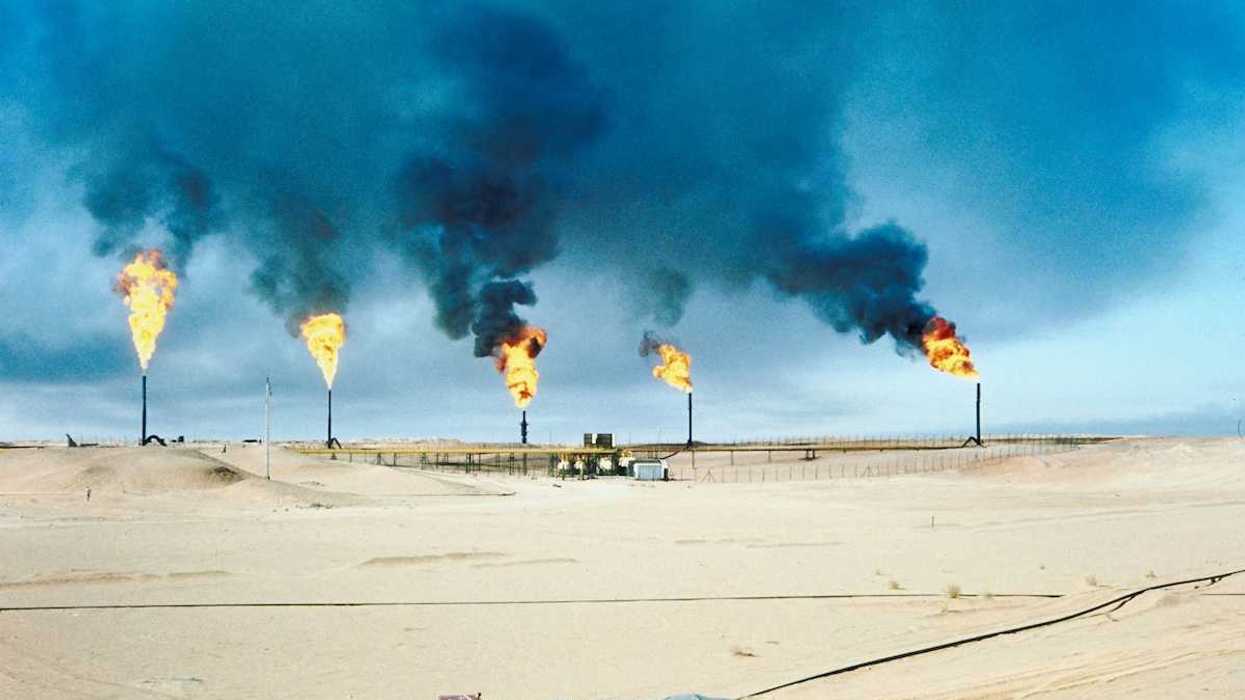 Five oil and gas wells burning off methane in a desert (Middle East?) environment.