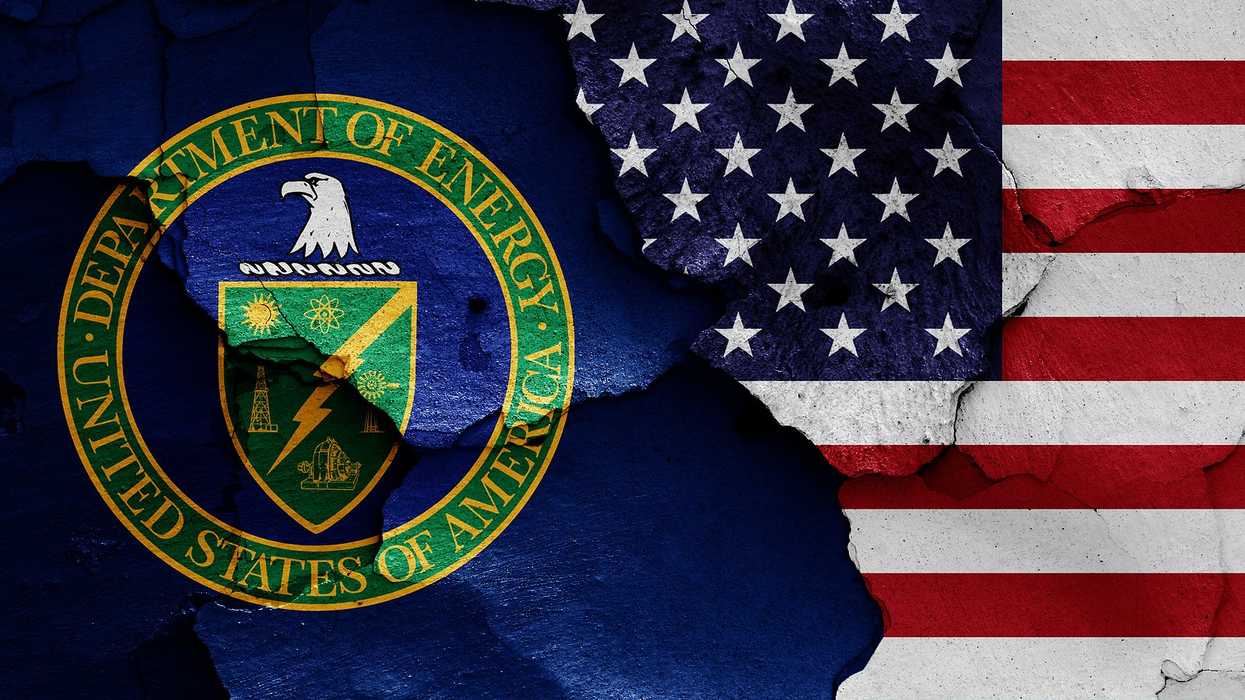 flags of Department of Energy and USA painted on cracked wall