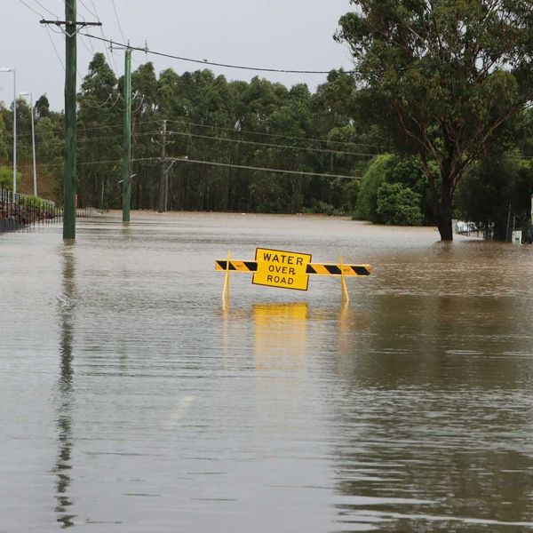 Flooded road with sign "Water Over Road."