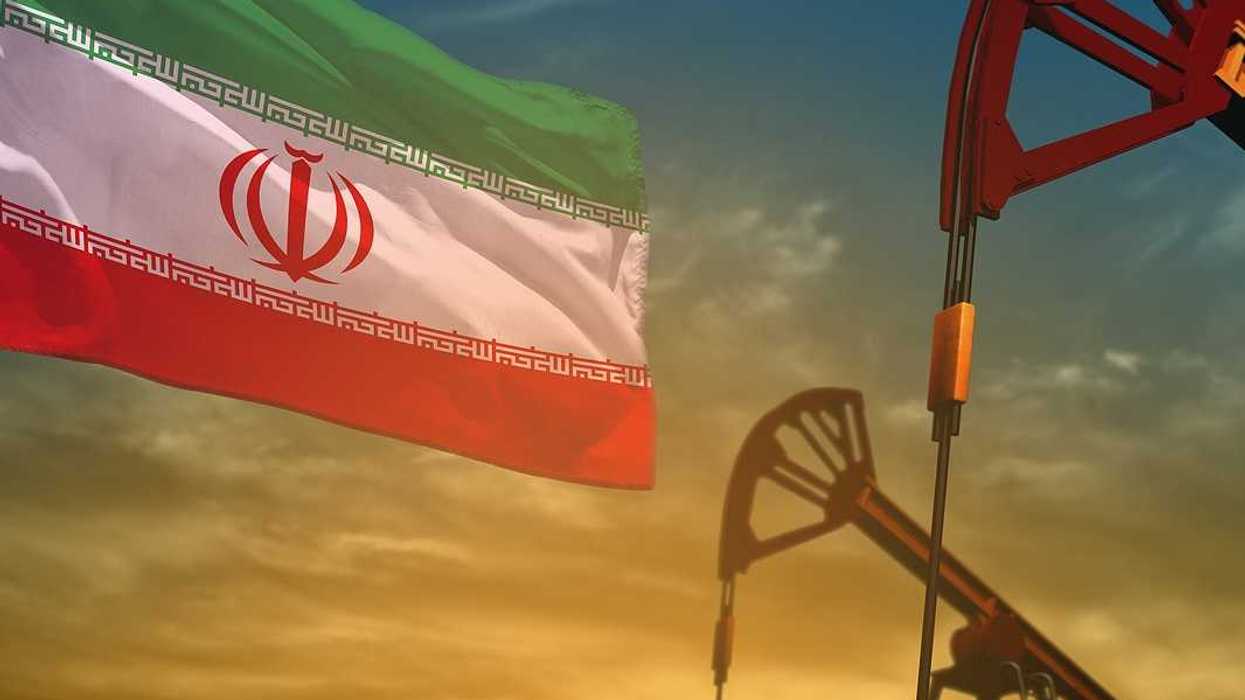 Fluttering Iran flag and oil wells on the blue and yellow sunset sky background