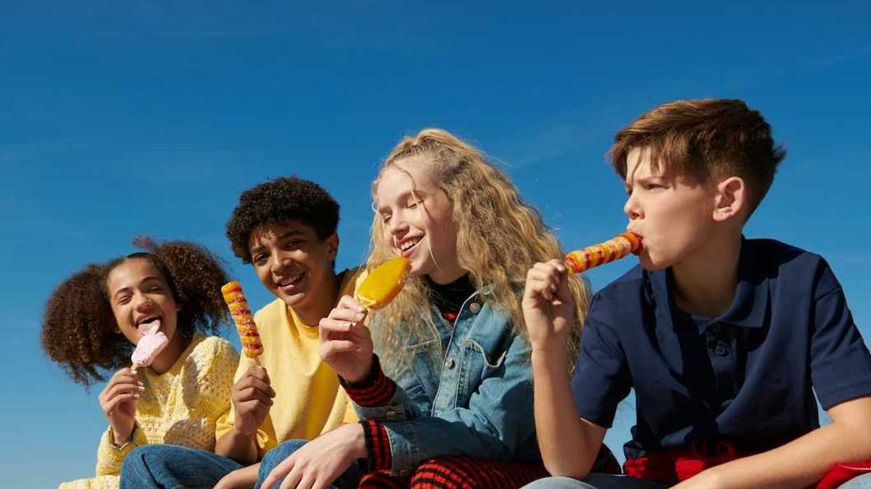 Four adolescent-aged kids eating snack foods