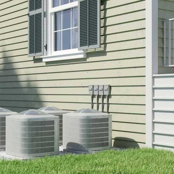 Four air conditioning units positioned next to a residential structure