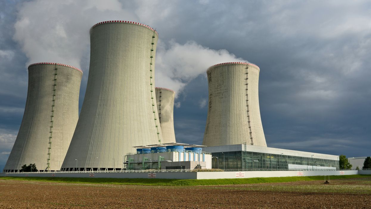 Four nuclear cooling towers set against a cloudy sky