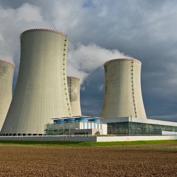Four nuclear cooling towers set against a cloudy sky