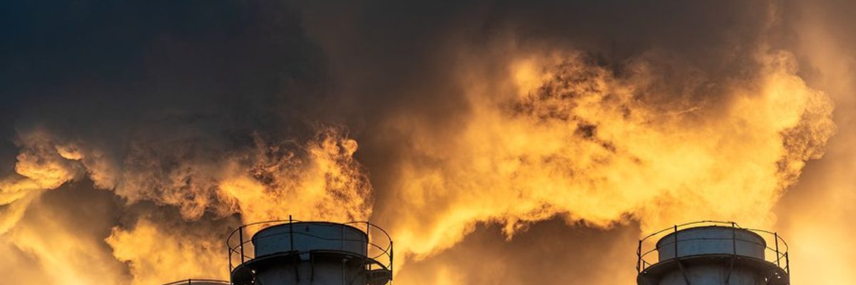 Four smokestacks billowing pollution