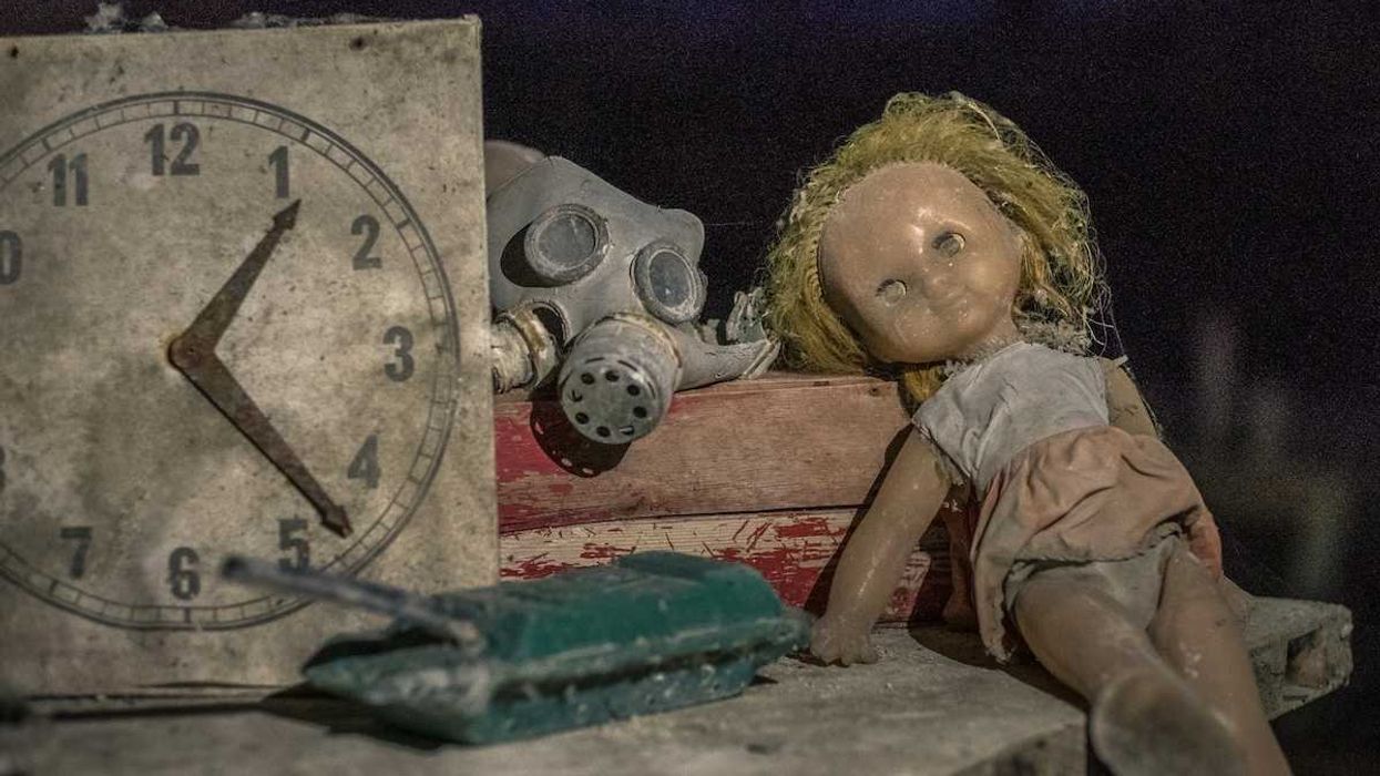 gas mask, doll, toy tank, and clock reading 1:23 symbola of Chernobyl and children