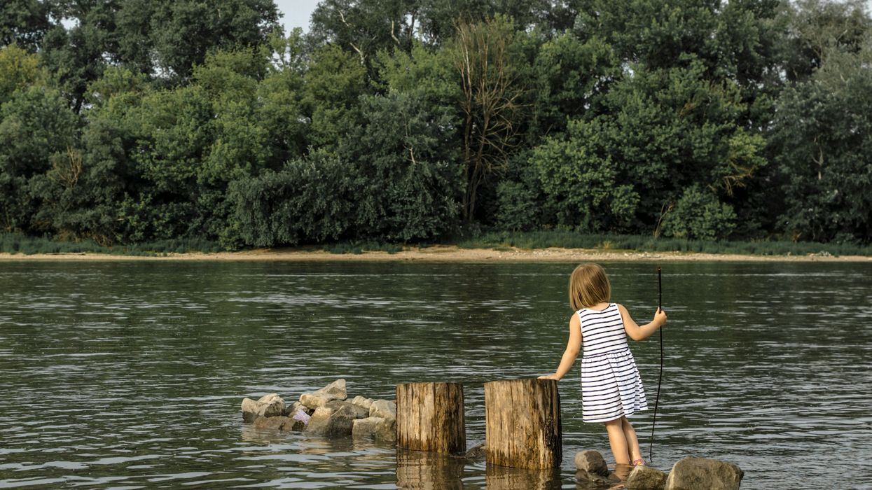 girl playing at river pollution