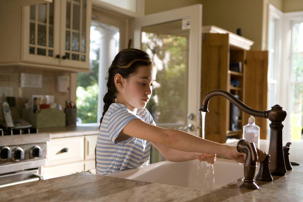 girl washing her hands at sink