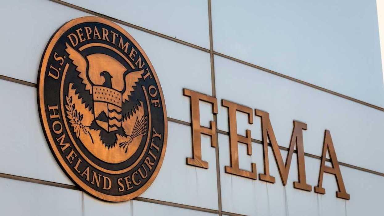 Gold-colored FEMA sign on building adjacent to Department of Homeland Security logo