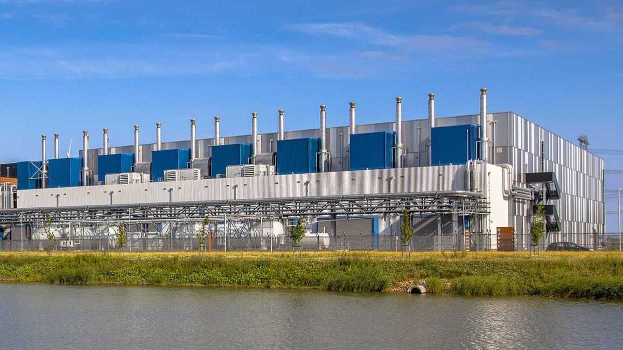 Google Datacenter adjacent to a waterway near Delfzijl in the province of Groningen, Netherlands, under blue sky.
