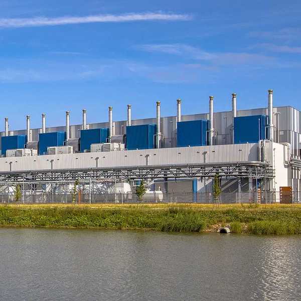 Google Datacenter adjacent to a waterway near Delfzijl in the province of Groningen, Netherlands, under blue sky.