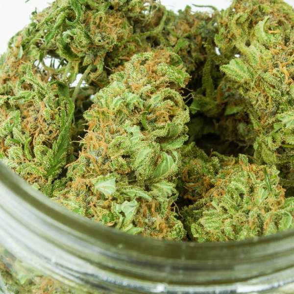 green kush in clear glass jar