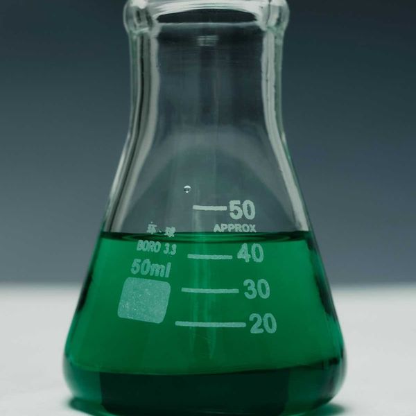 Green liquid in a glass beaker representing green chemistry