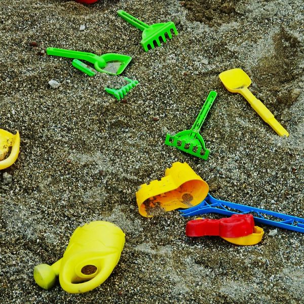 Green yellow and red plastic sandbox toys.