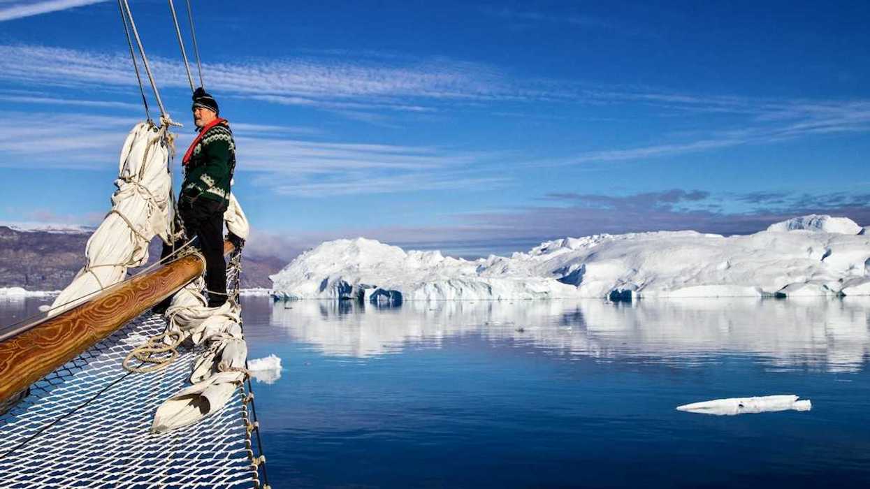 Greenland fisherman on his boat with ice floes in background