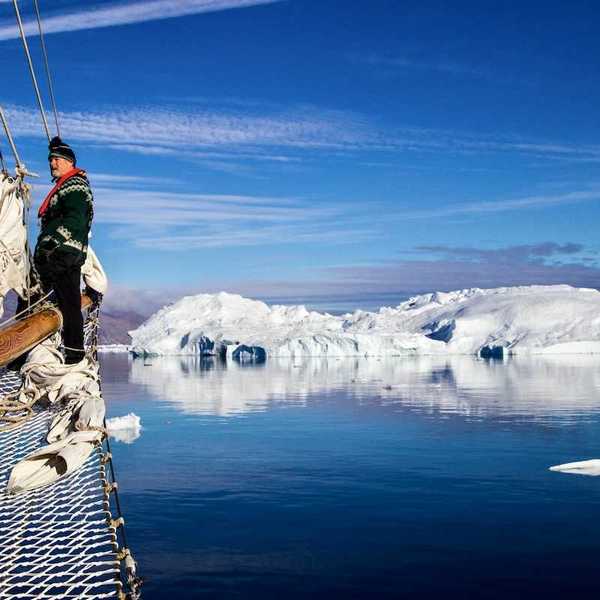 Greenland fisherman on his boat with ice floes in background