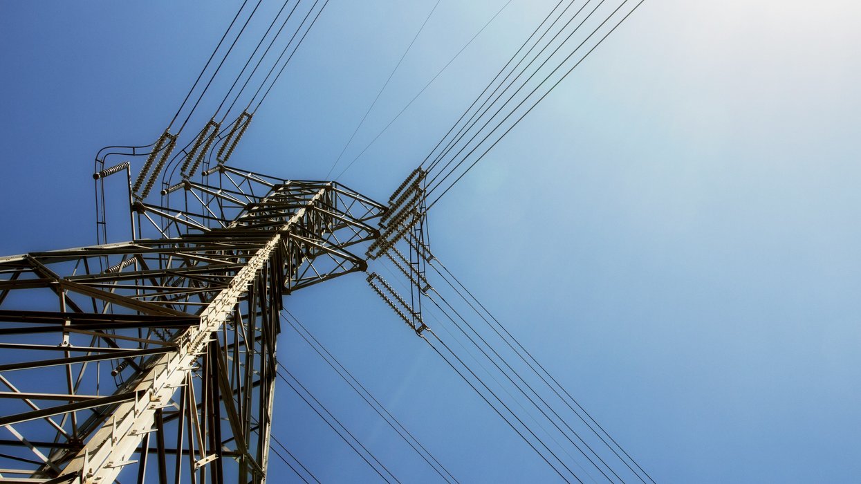 Grey and black utility tower viewed from below on a sunny day