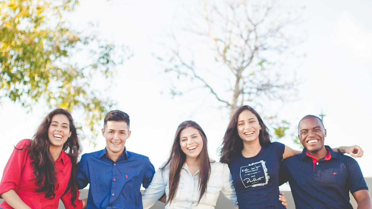 group of young people sitting on bench near trees duting daytime