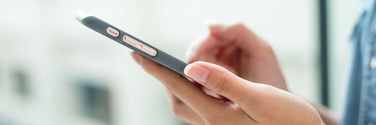 Hands holding a gray smartphone.