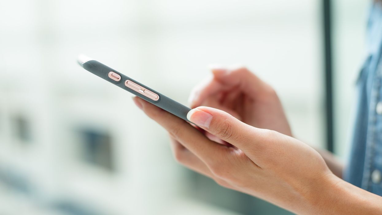 Hands holding a gray smartphone.