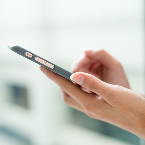 Hands holding a gray smartphone.
