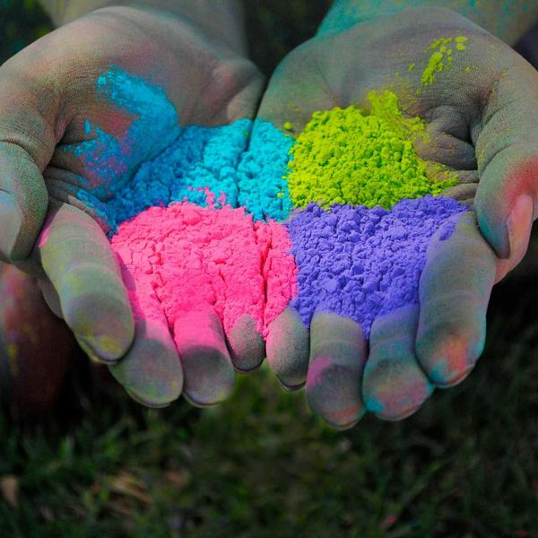 hands holding rainbow colored sand